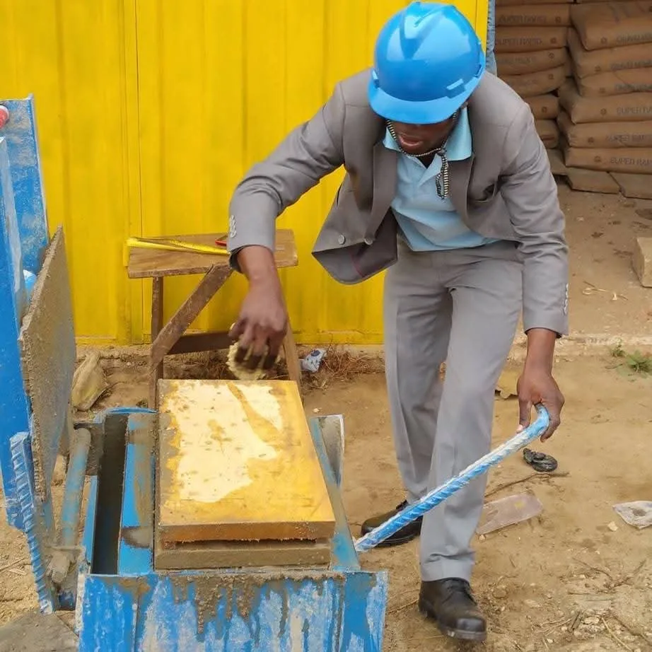 Operator moulding concrete blocks on a manual press at Quasi Blockfactory